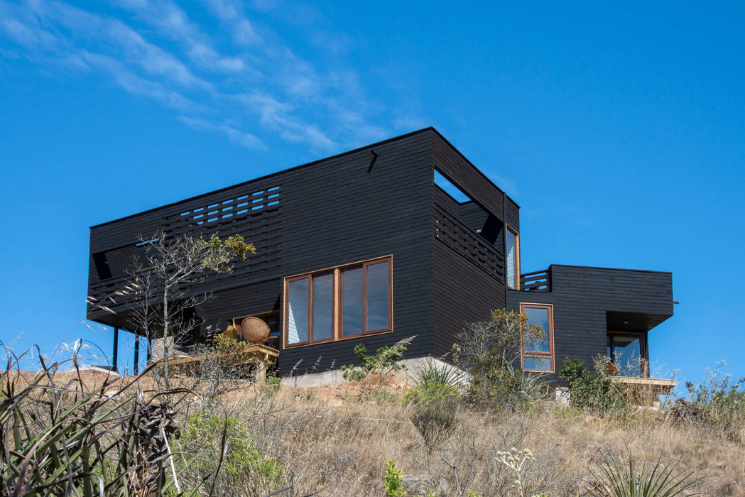 vista frontal, fachada suroriente Thomas Löwenstein arquitecto Casas de estilo rústico los molles,segunda vivienda,casa de playa,casa de madera,rocas del mar,fachada de madera