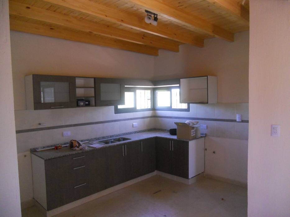 Cocina funcional y equipada con techos planos en madera a la vista