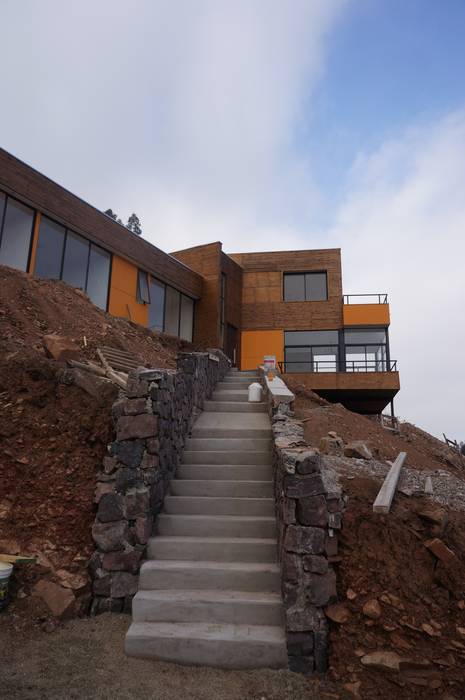 Vista acceso peatonal en obra. Uno Arquitectura Casas unifamiliares Piedra