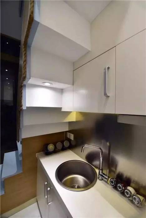Một căn bếp hiện đại được đặt ngay cạnh cầu thang. Công ty TNHH TK XD Song Phát Nhà bếp phong cách châu Á Đồng / Đồng / Đồng thau