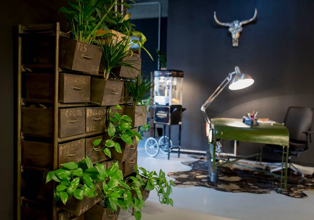 A vintage drawer as plant holder, a cow rug and an old car part reception desk Ivy's Design - Interior Designer aus Berlin Ausgefallene Arbeitszimmer Plastik