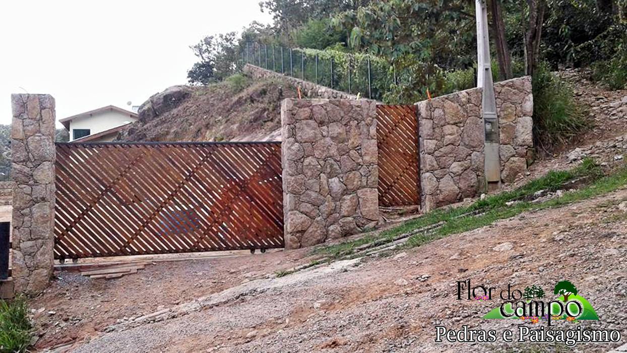 Muro de pedra na entrada da residencia Flor do Campo Pedras e Paisagismo Paredes e pisos rústicos
