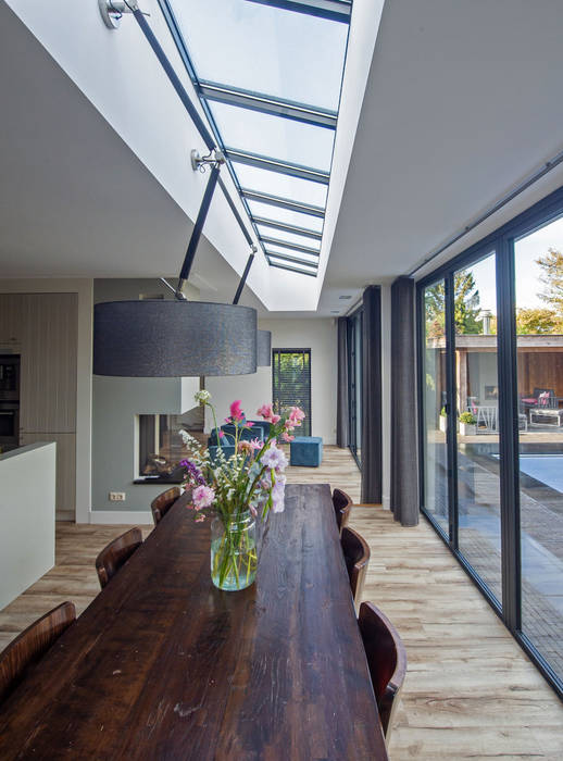 MODERNE AANBOUW MET HARMONICADEUREN EN GROOT DAKLICHT ID-Architectuur Moderne eetkamers Glas Gebouw,Tafel,Eigendom,Meubilair,Venster,Plant,Hout,Schaduw,huis,Interieur ontwerp