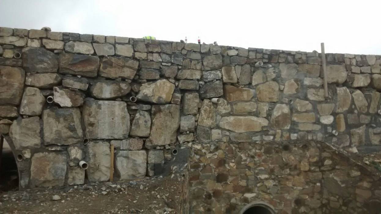 Puente con muro de mampostería. Trevalo Construcciones y Urbanizaciones Paredes y pisos de estilo rústico Piedra