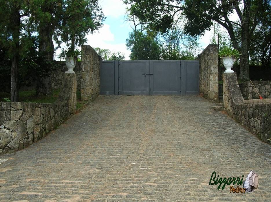 Muro de pedra com portão de ferro na entrada da residência. Bizzarri Pedras Corredores, halls e escadas rústicos Pedra pedras,muros,jardins,paisagismo,ponte de madeira,caminhos