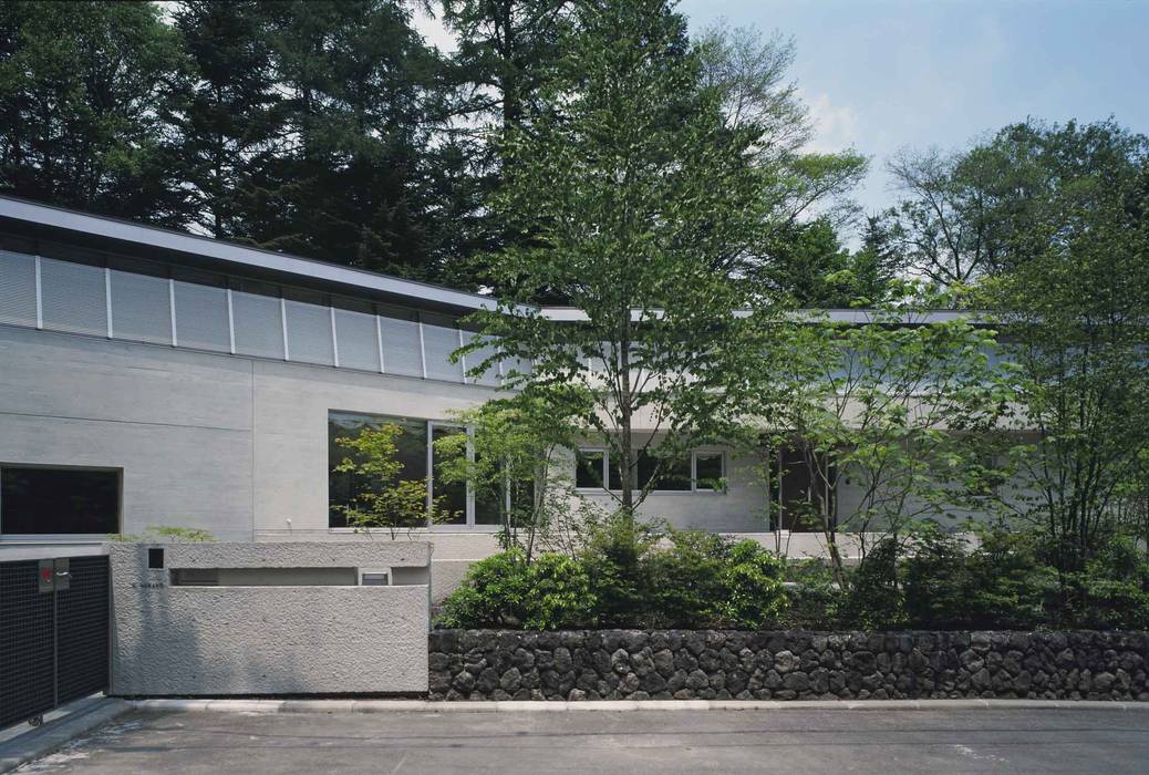中軽井沢：原生林にいだかれ、暖炉のある伸びやかな住まい, JWA，Jun Watanabe & Associates JWA，Jun Watanabe & Associates Modern home