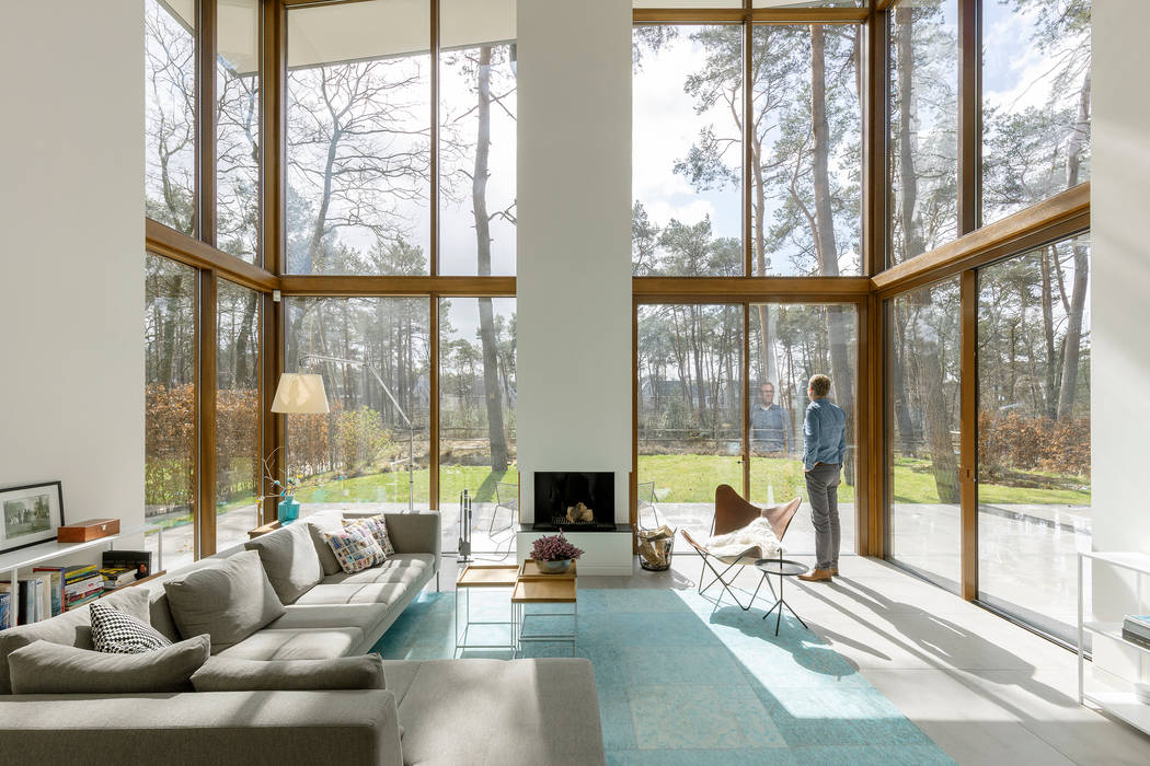 De vide geeft een sterk ruimtelijk gevoel. Engel Architecten Moderne woonkamers vide,glas,modern,openhaard