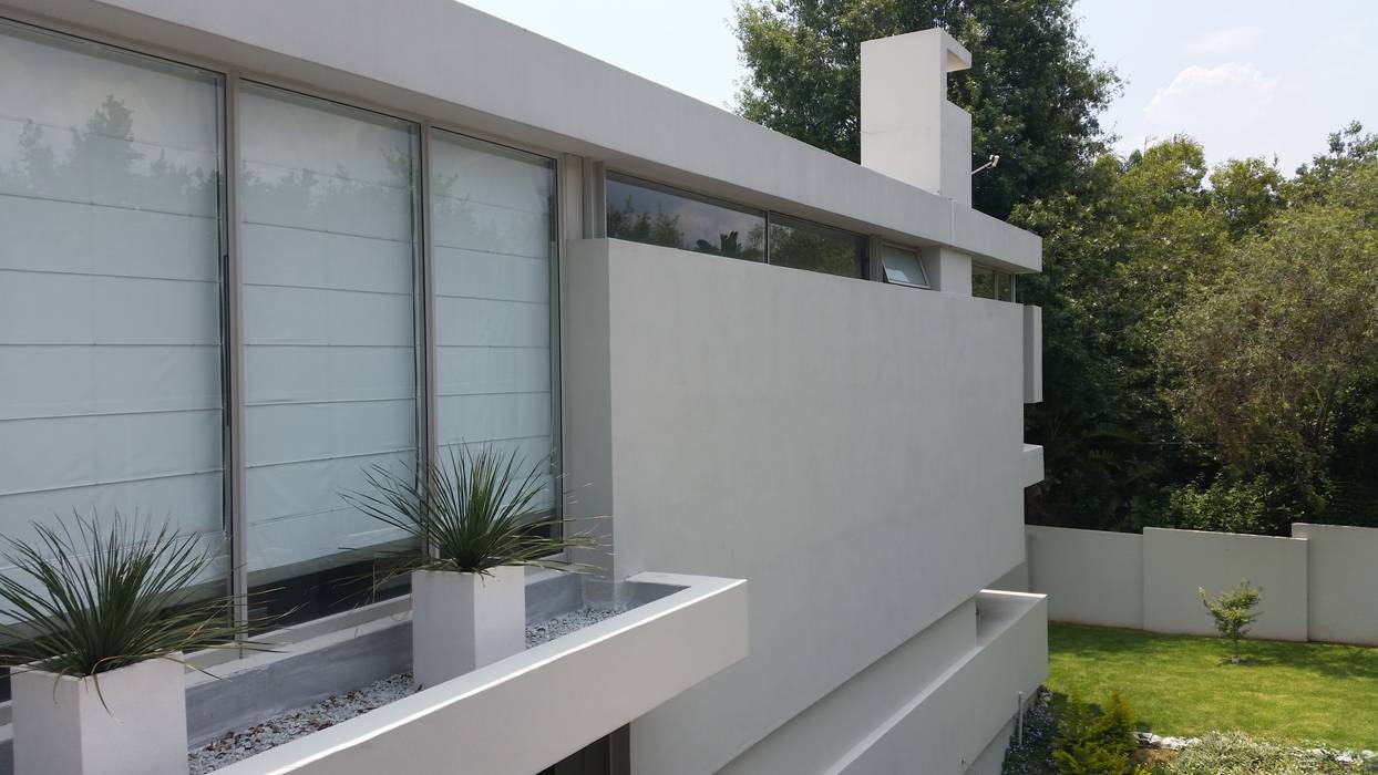 Detail view of the modern minimalist facade to the rear of the house. Floating wall panels and strip windows work to enforce the idea of independant vertical and horizontal planes Green Evolution Architecture Minimalist house Reinforced concrete