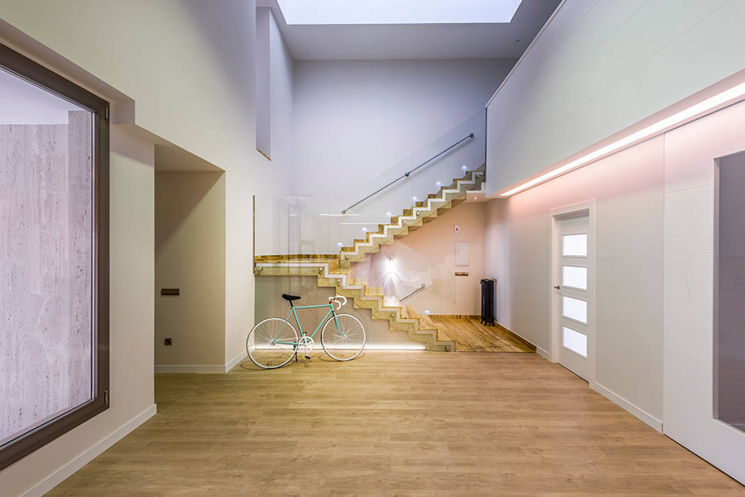 Escalera de hormigón presidiendo espacio a doble altura. de ooiio arquitectura moderno madera
