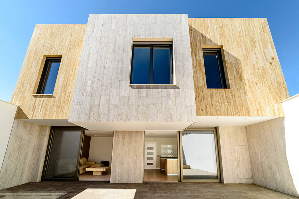 Fachada trasera a patio y porche. OOIIO Arquitectura Casas prefabricadas Piedra