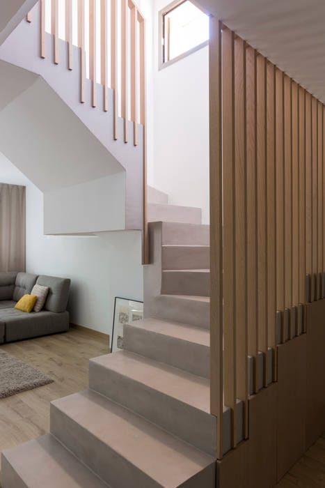 Escalera de microcemento con barandilla de madera maciza, diseñado a medida por nuestro estudio. HoffmannWehr | Arquitectura & diseño interior Escaleras Madera Acabado en madera Barandilla de madera, microcemento