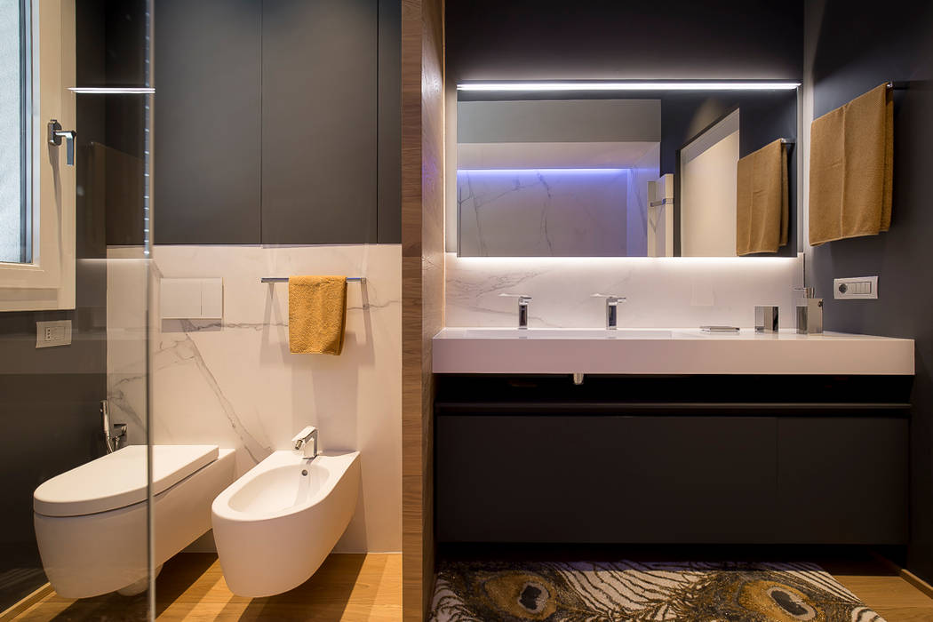 Servizi e mobile bagno padronale Essestudioarch Bagno moderno parquet in rovere, piano lavandino in Corian, parte divisoria rovere, sanitari, rivestimento gres, armadio a parete, specchio con luce lineare