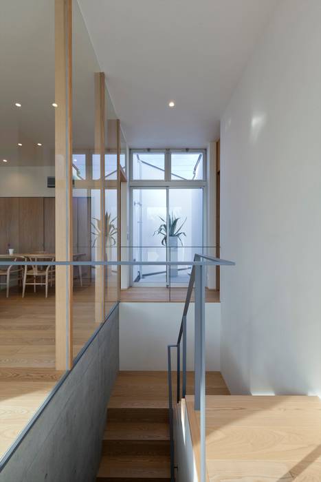 ガラスパーティションで仕切られた階段室 Y Architectural Design 階段 無垢材 白色 Homify