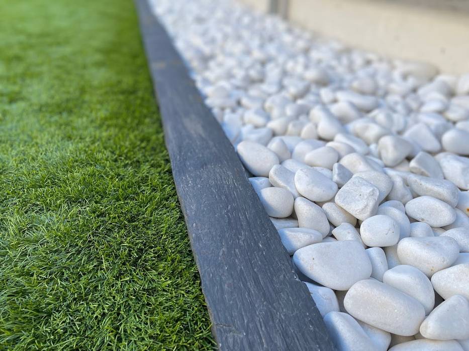 Garden with artificial grass and white pebbles separated by a slate border. Canteras el Cerro Modern Garden Marble Accessories & decoration