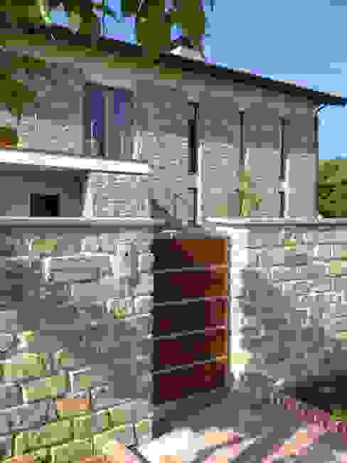 Villa unifamiliare a Bastia Umbra (PG) Fabricamus - Architettura e Ingegneria Case moderne muro in pietra,pietra a vista,facciavista,feritoie,cancello,cancello pedonale,esterno in legno