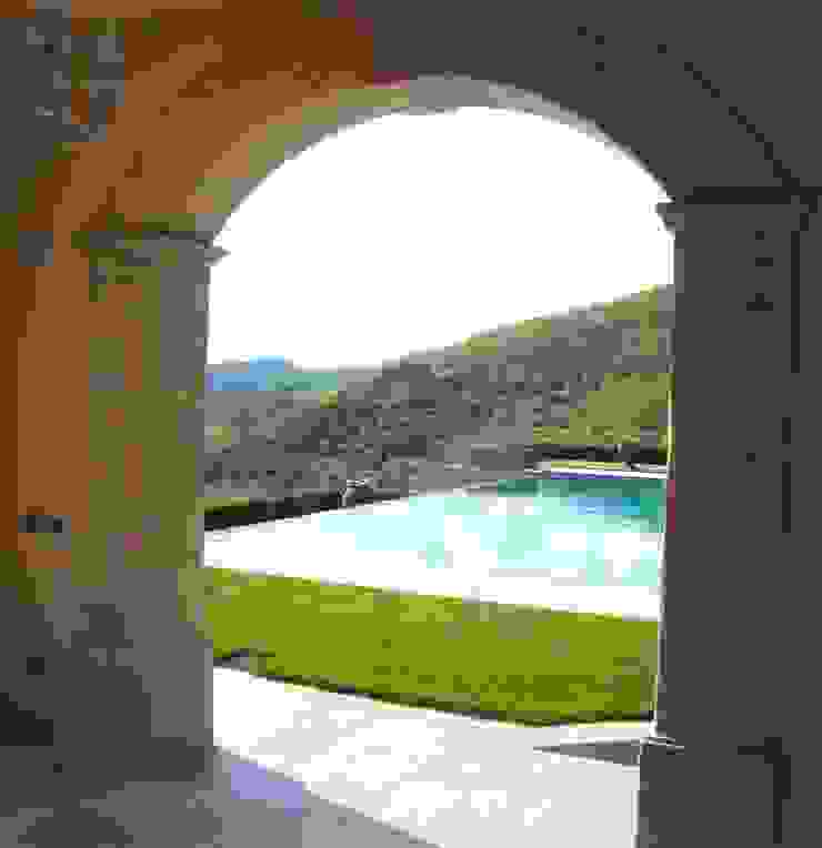 Arco in pietra, piscina a sfioro. Garden House Lazzerini Giardino classico Marmo Ambra/Oro