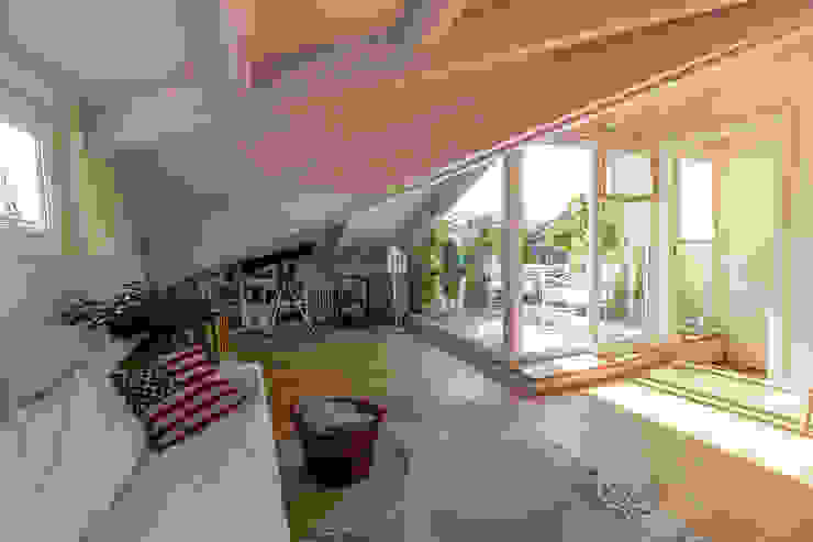 Mansarda Bartolucci Architetti vetrata,travi in legno,pavimento in legno,colori caldi,legno dipinto bianco,angolo accogliente