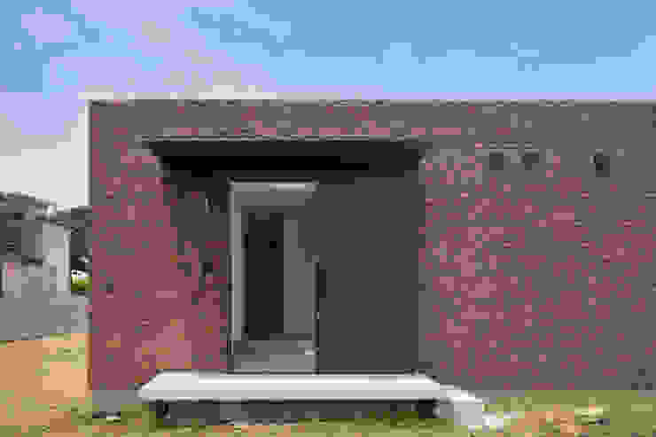 30 坪的工业风平房: 一间有砖墙以及大片落地窗的现代空间