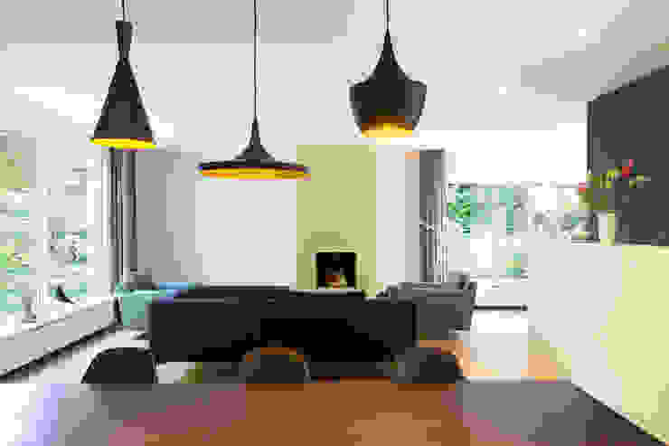 Open woonkamer met openhaard in goudkleur StrandNL architectuur en interieur Moderne woonkamers