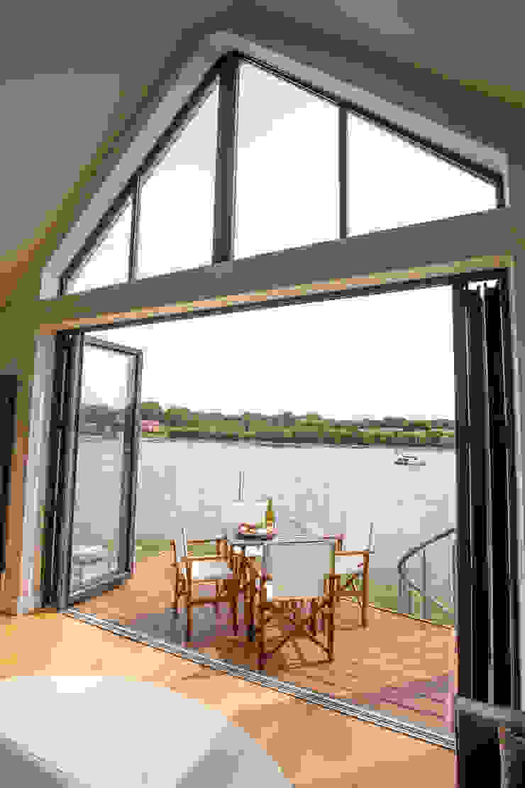 View of high-level window, bi-folding doors and balcony from living room โดย dwell design โมเดิร์น