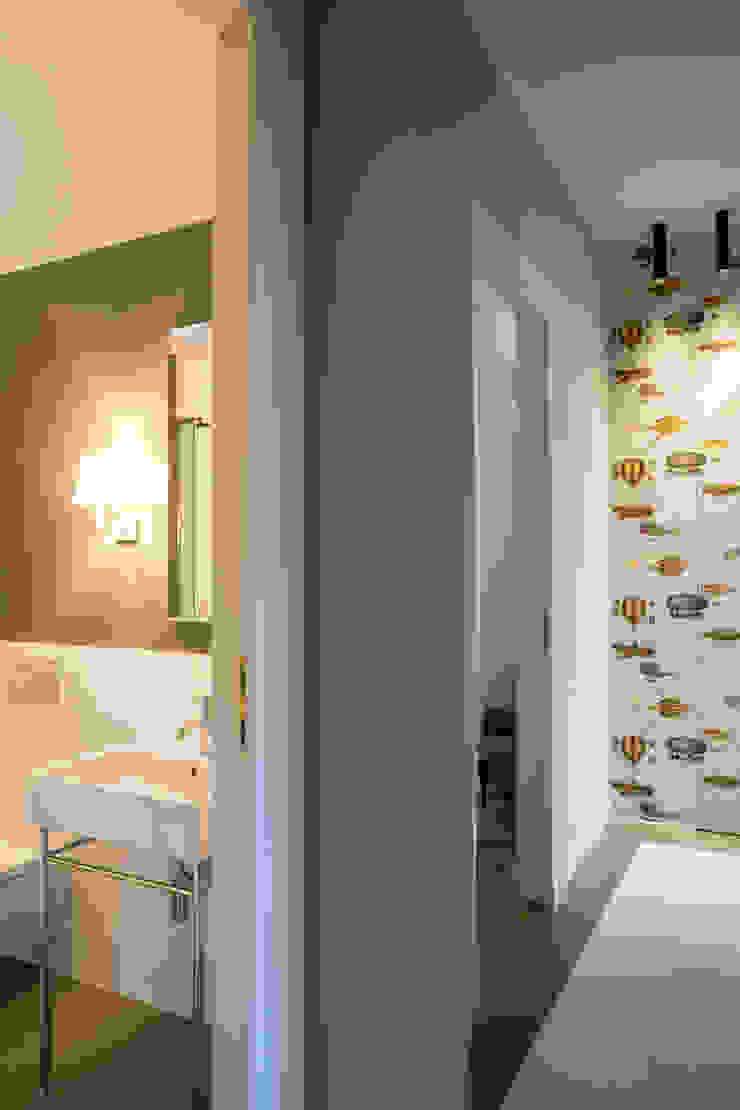 Il corridoio e il bagno ospiti Matteo Magnabosco Architetto Ingresso, Corridoio & Scale in stile moderno cementine carta da parati verde oliva piastrelle bianche lavabo lavandino consolle ospiti specchio fornasetti