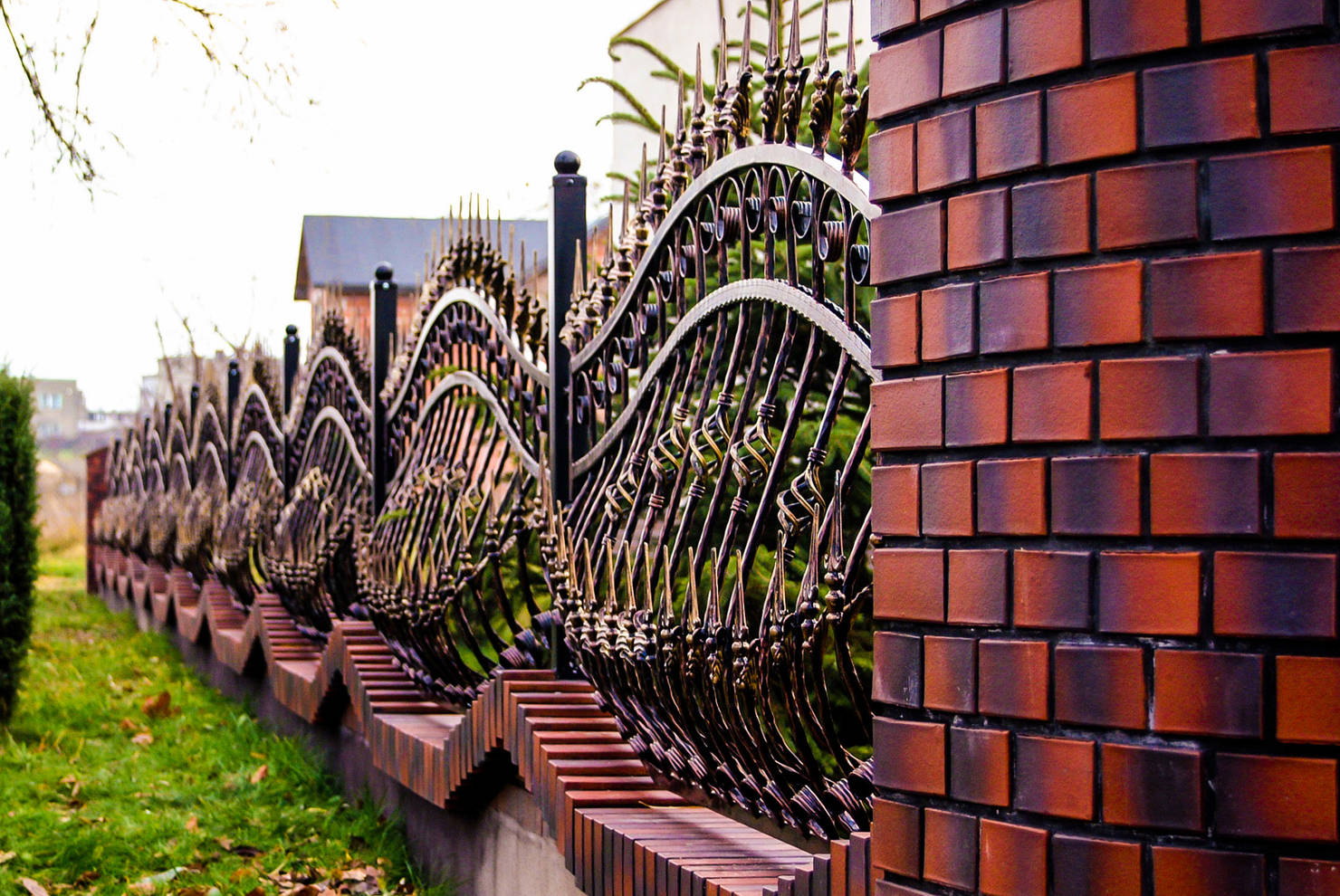 Стильный кованый забор на фундаменте из кирпичей с эффектом неравномерного обжига или омбре
