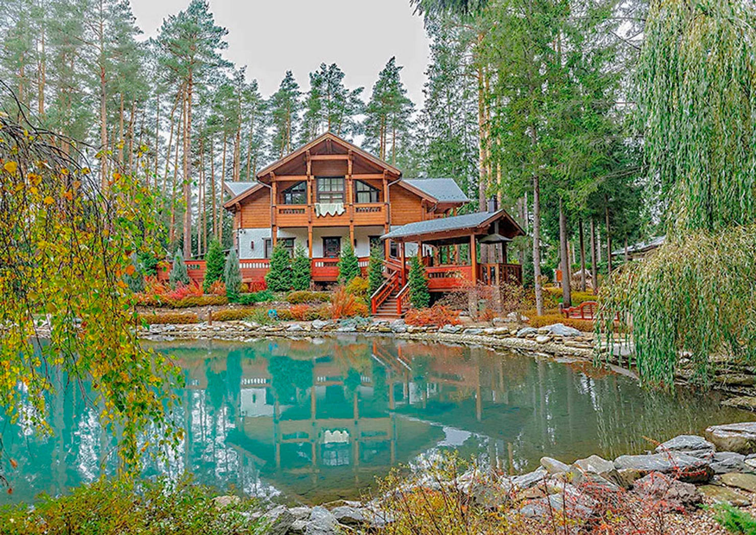 Деревянный дом с искусственным водоемом