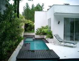 Casa minimalista na metrópole: Piscinas tropicais por Kika Prata Arquitetura e Interiores.