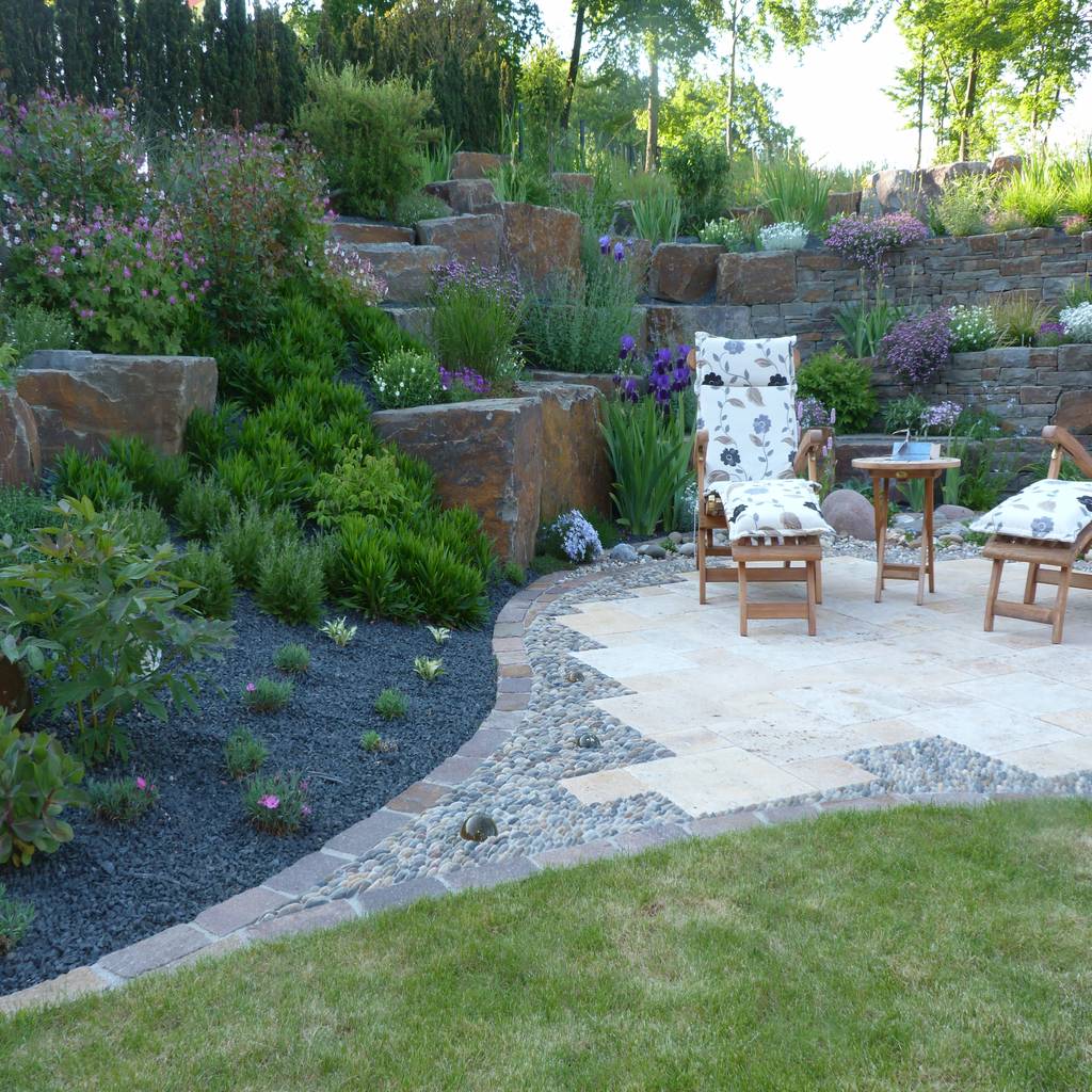 Eine kleine terrasse lädt zum verweilen ein. gärten für auge und seele