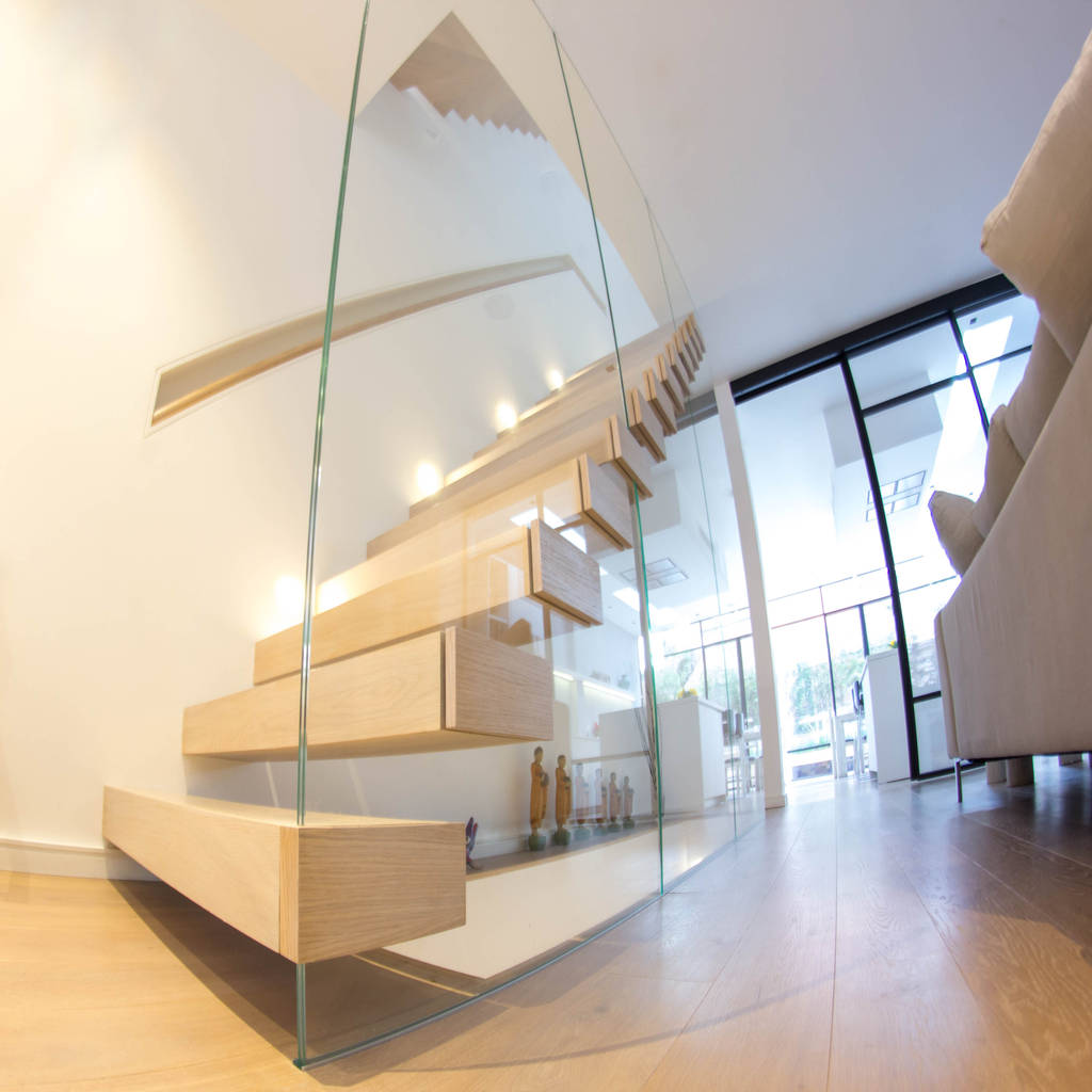 A minimalist floating staircase with oakclad treads and glass wall