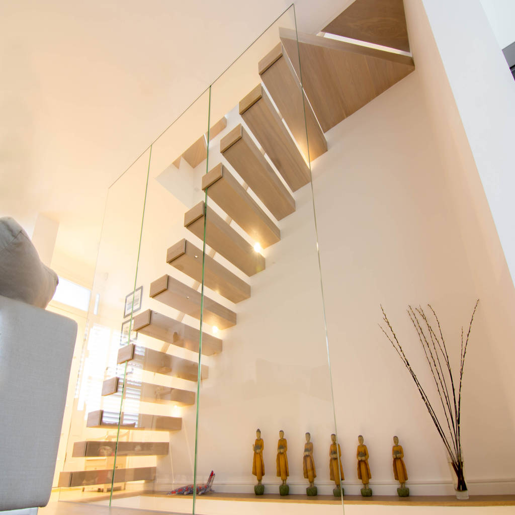 A minimalist floating staircase with oakclad treads and glass wall