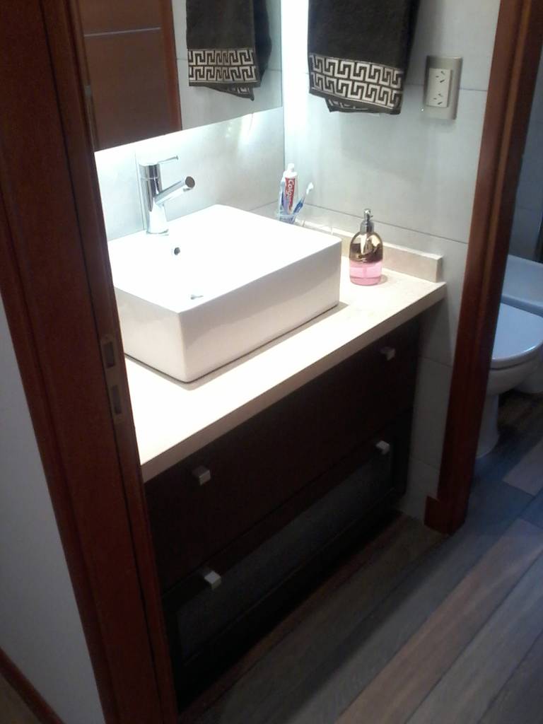 Detalle del mueble vanitory a medida con mesada mármol beige, bacha de