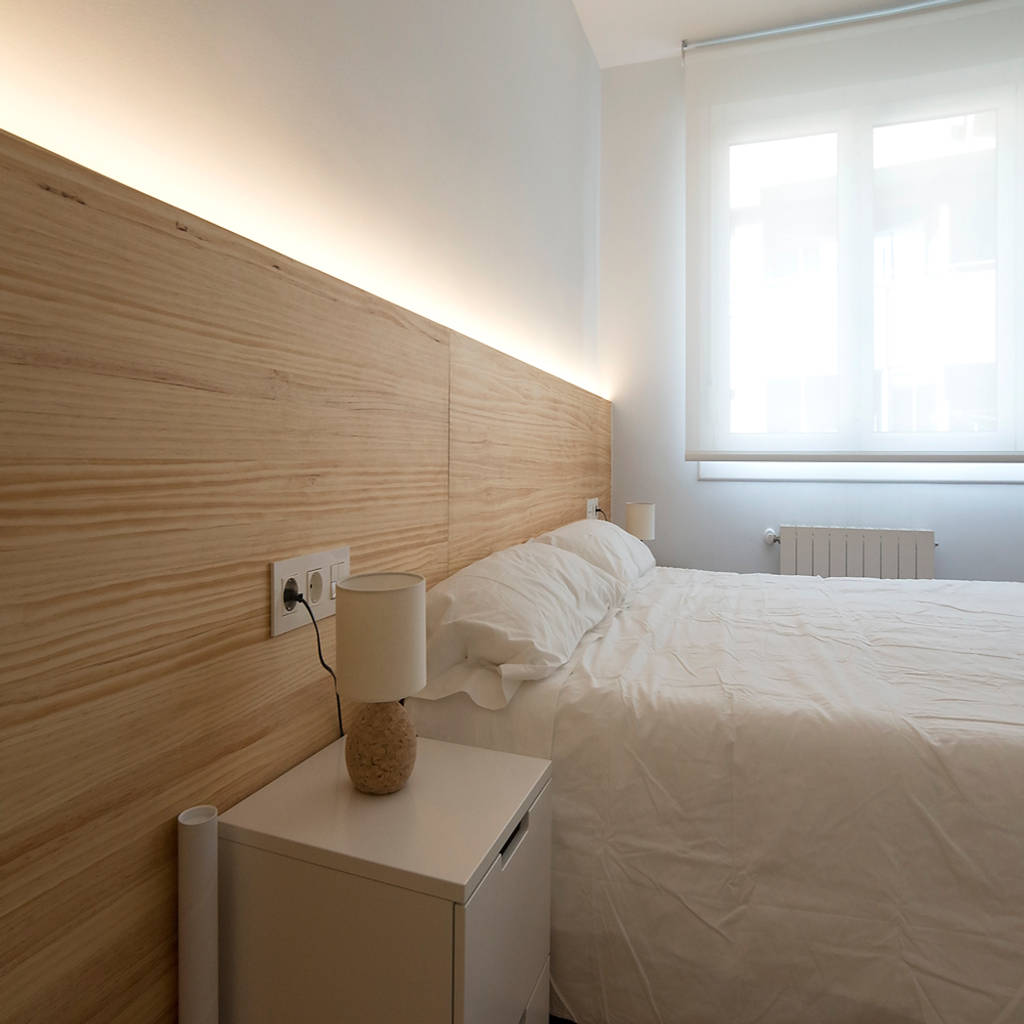 Dormitorio principal con cabecero de pino e iluminación led integrada
