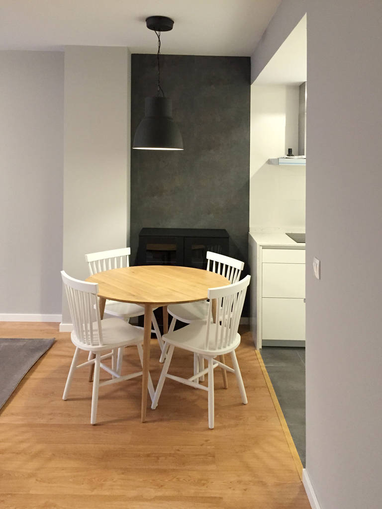 Comedor con mesa de madera clara y sillas de madera pintadas de blanco