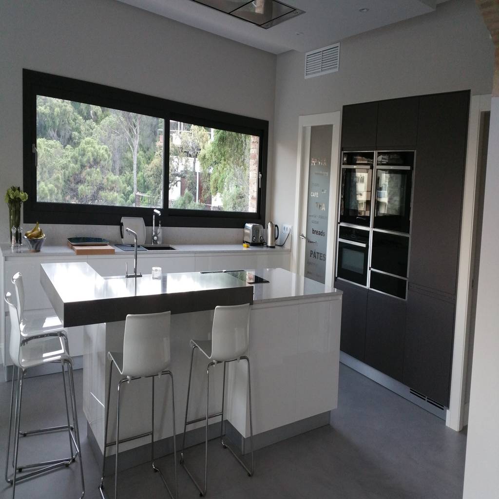 Muebles columnas, isla central y barra con taburetes de decodan