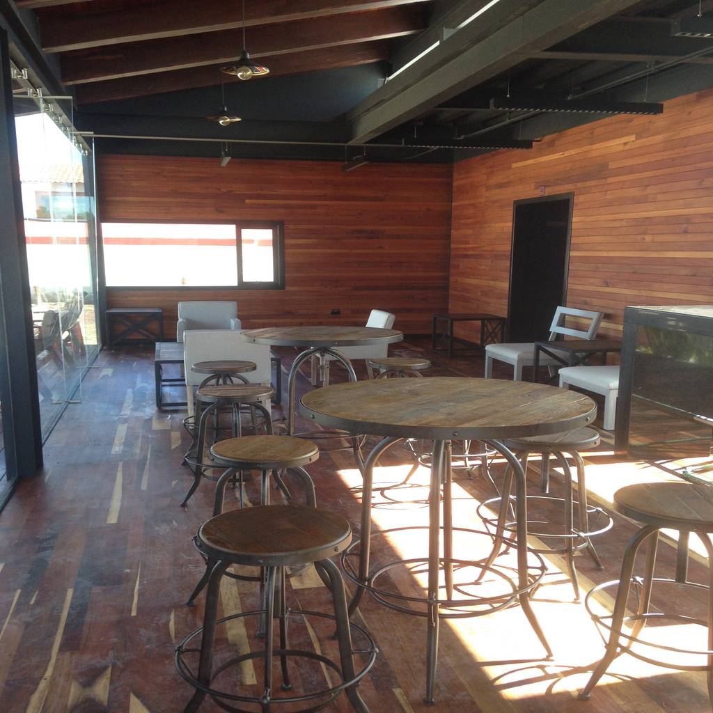 Salón interior de cabaña de madera estilo rustico y terraza en complejo