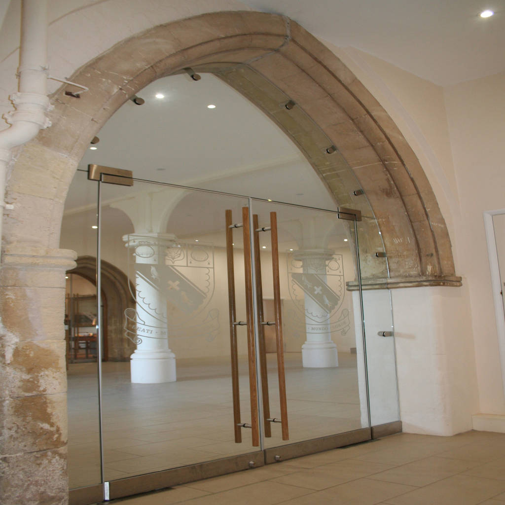 Frameless glass doors with school logo homify