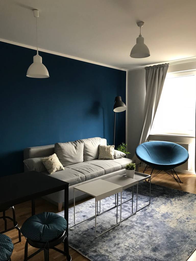 Bequemes Wohnzimmer Mit Mutiger Blauer Wand Und Schaukelstuhl