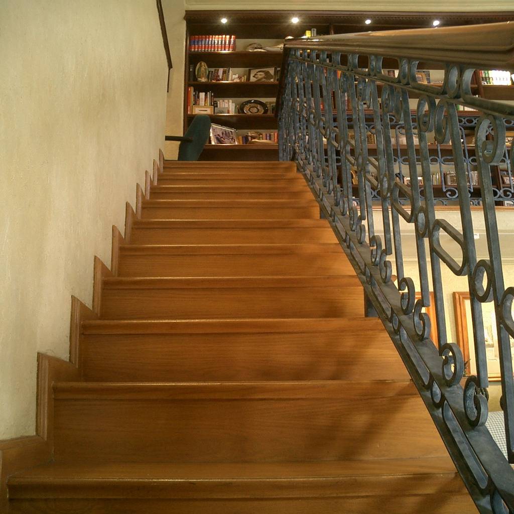 Escalera con piso de madera y barandal con forja de hierro de dimarq