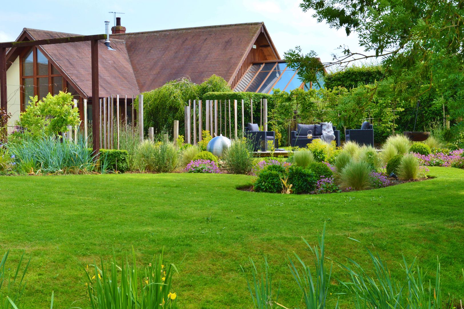 Traditional Garden - Decked Seating Area and Vertical Wooden Screening Unique Landscapes Wiejski ogród