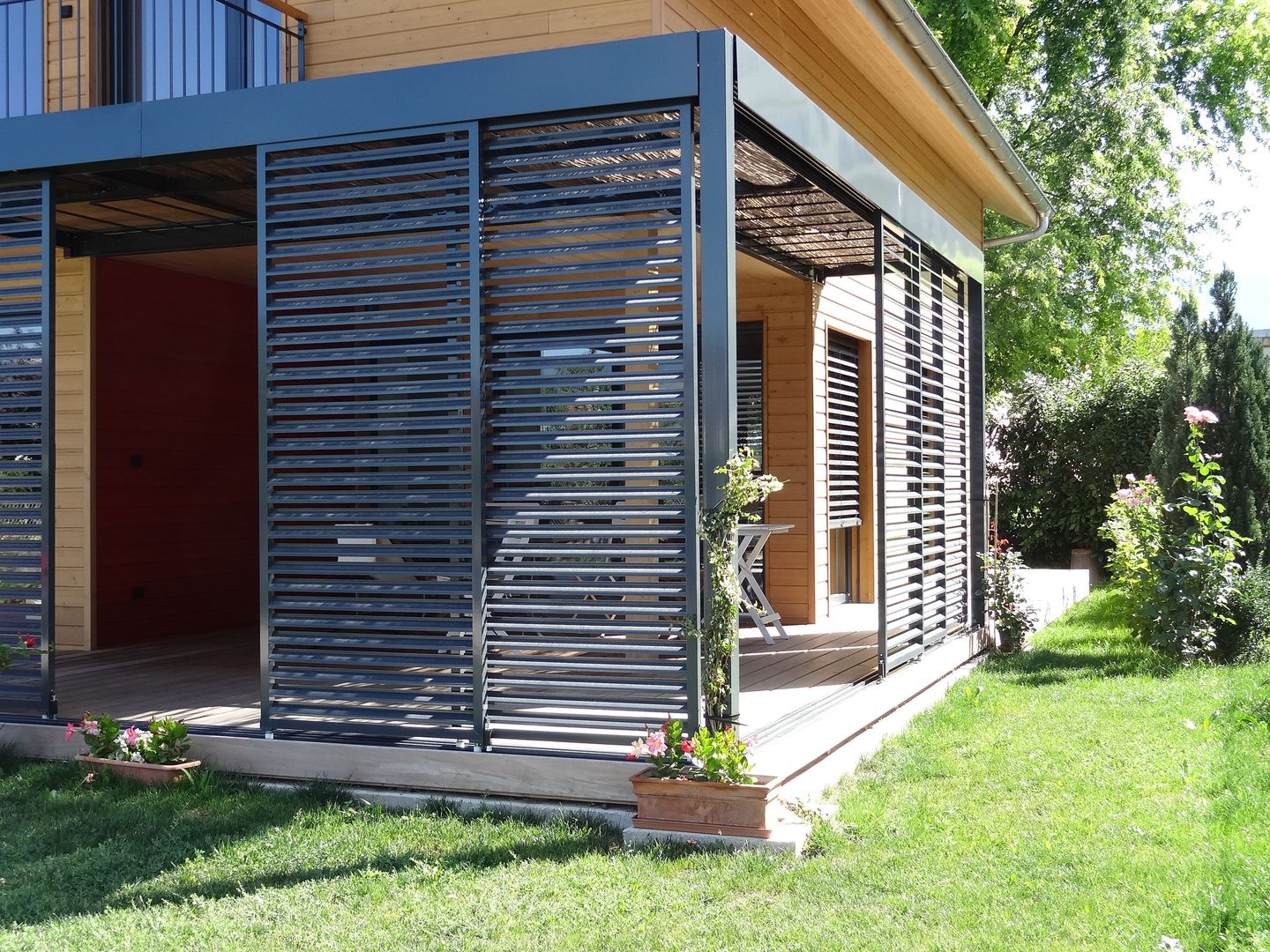 Panneaux coulissants brise-soleil de la terrasse Tangentes Architectes Maisons modernes