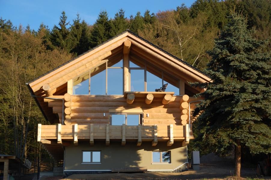 Blockhäuser, eb Massivhaus Deutschland GmbH eb Massivhaus Deutschland GmbH Ausgefallene Häuser Himmel,Pflanze,Baum,Gebäude,Schatten,Holz,Neigung,Landschaft,Dach,Hütte