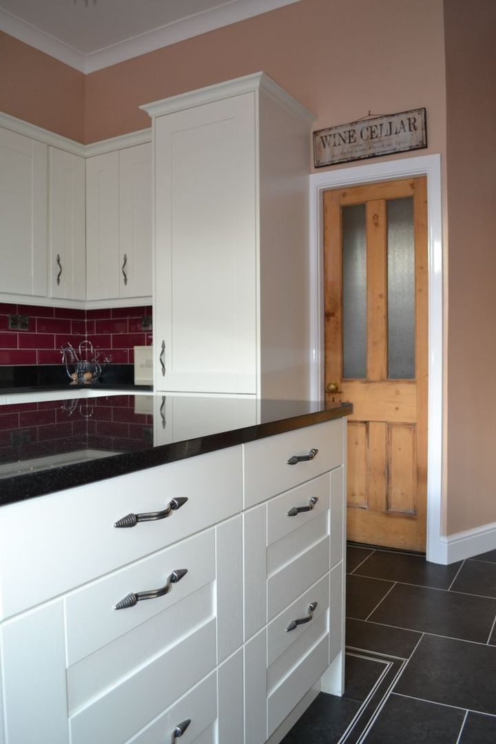 Wentworth Kitchen Units in Alabaster with black granite worktops and cranberry wall tiles. Statement Kitchens