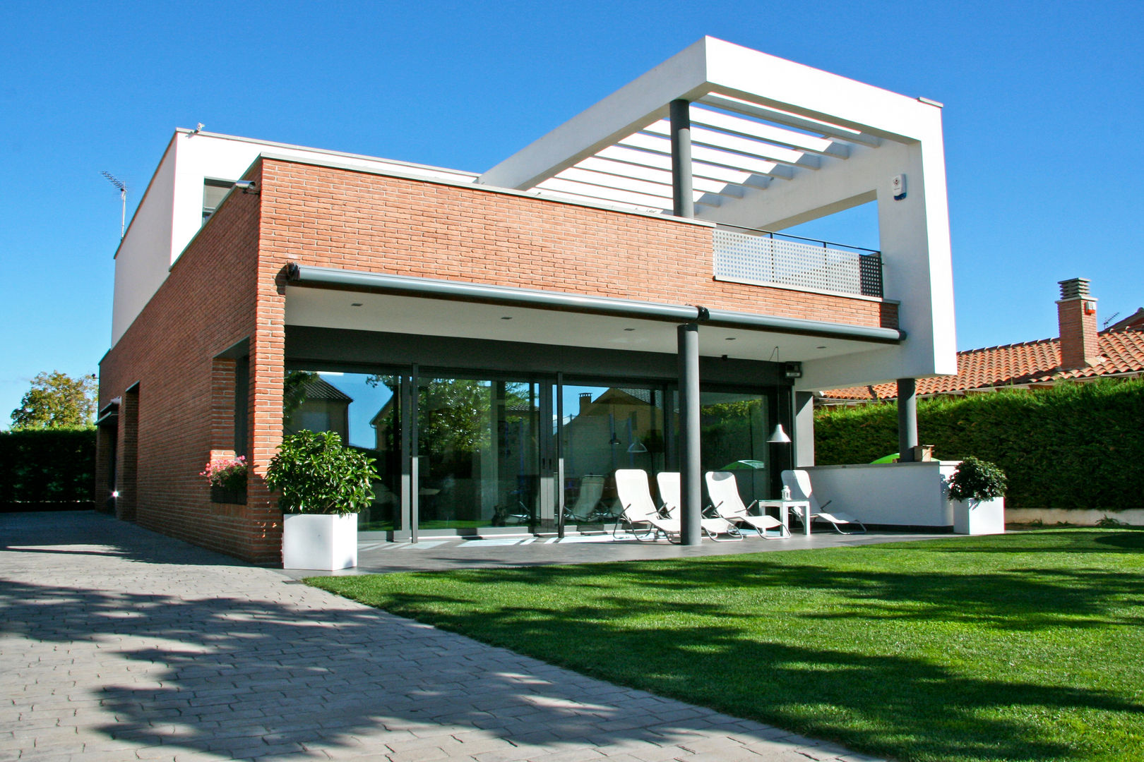 Main façade and garden FG ARQUITECTES Nowoczesne domy