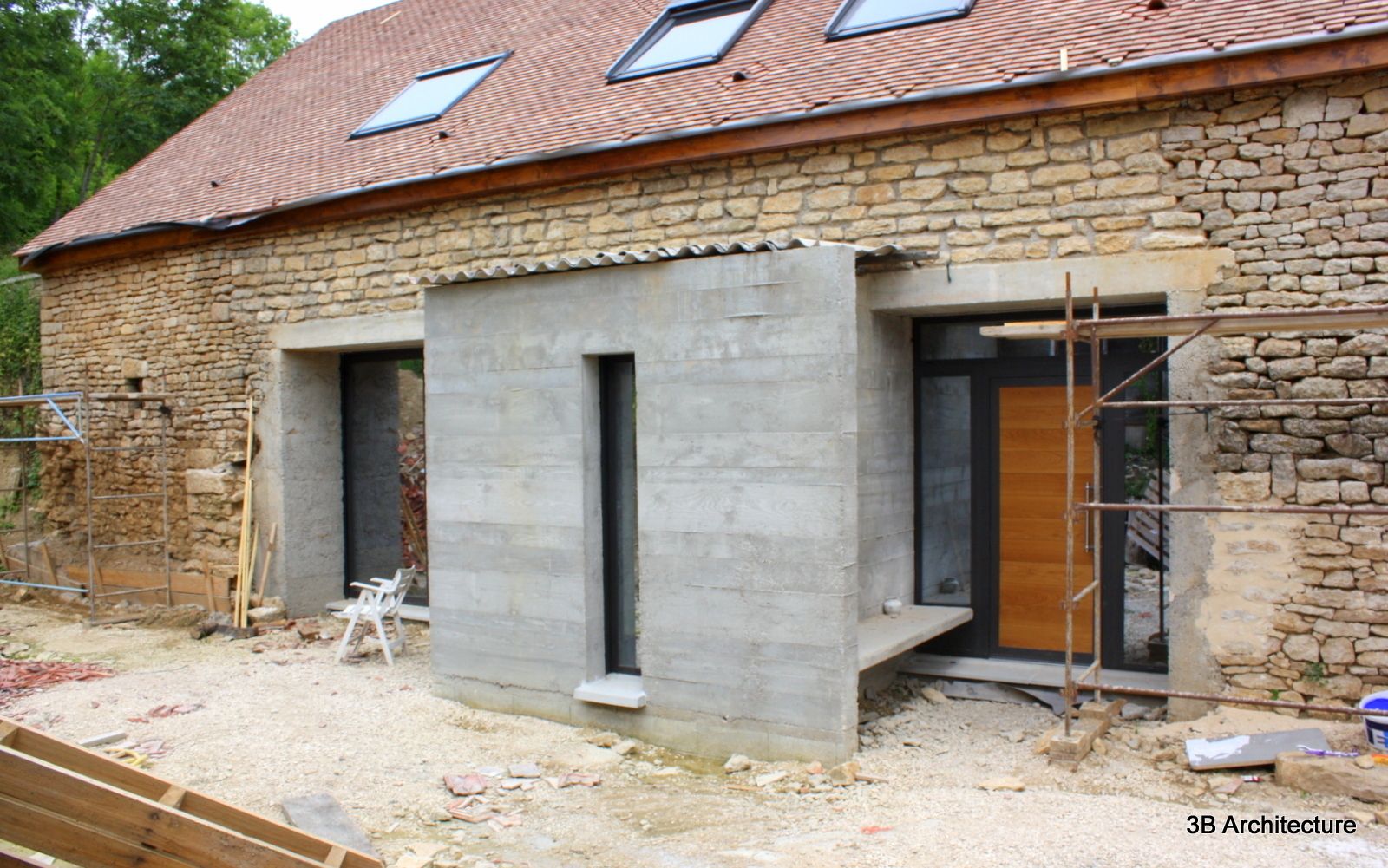 Façade d'entrée marquée par l'extension 3B Architecture Maisons modernes