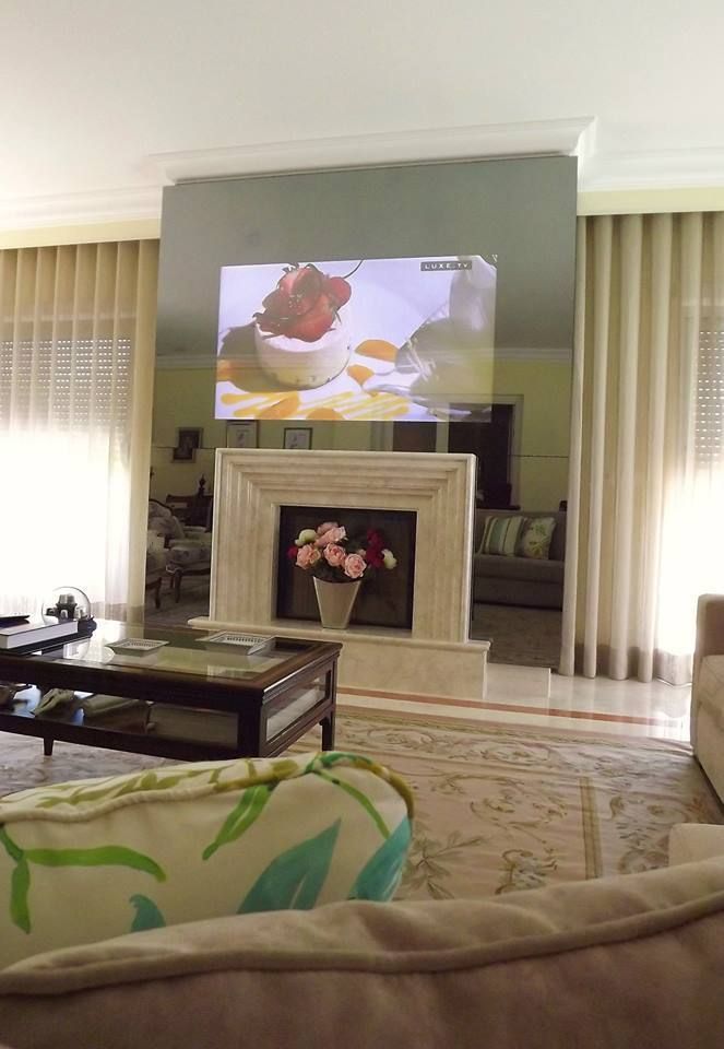 Lareira revestida com espelho para esconder a TV (TV ligada) Traço Magenta - Design de Interiores Salas de estar clássicas
