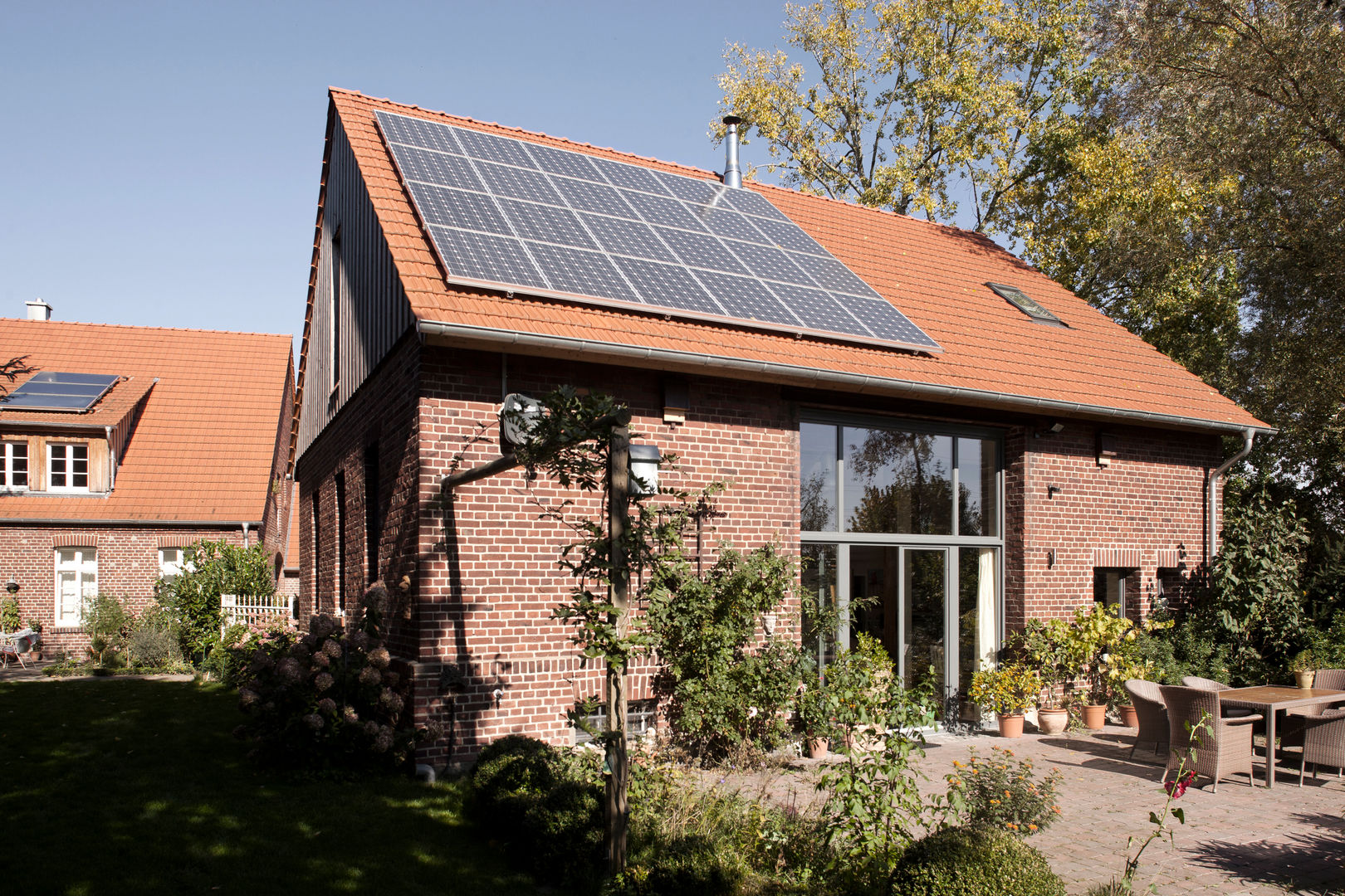 Ehemalige Scheune mit neuem Dach und Photovoltaikanlage Lecke Architekten Landhäuser Pflanze,Himmel,Fenster,Eigentum,Gebäude,Haus,Holz,Leuchte,Baum,Solarenergie