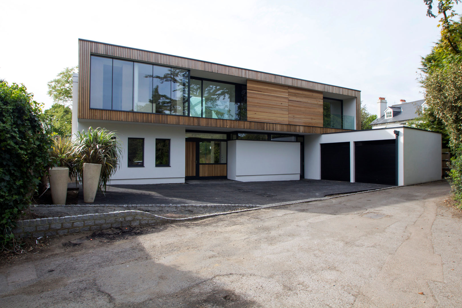The front elevation with timber-clad upper floor Hale Brown Architects Ltd Modern houses