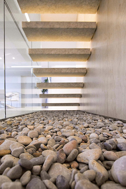 Vista trasera de la escalera de piedra con las piedras naturales - Casa Moncofa - Chiralt Arquitectos Chiralt Arquitectos Pasillos, vestíbulos y escaleras de estilo minimalista