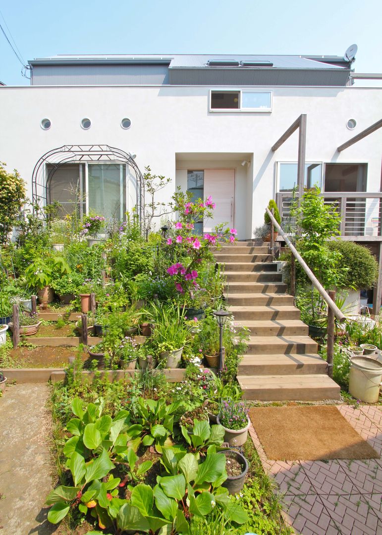 大きなお庭の2世帯住宅, ジェイ石田アソシエイツ ジェイ石田アソシエイツ Tropical style gardens